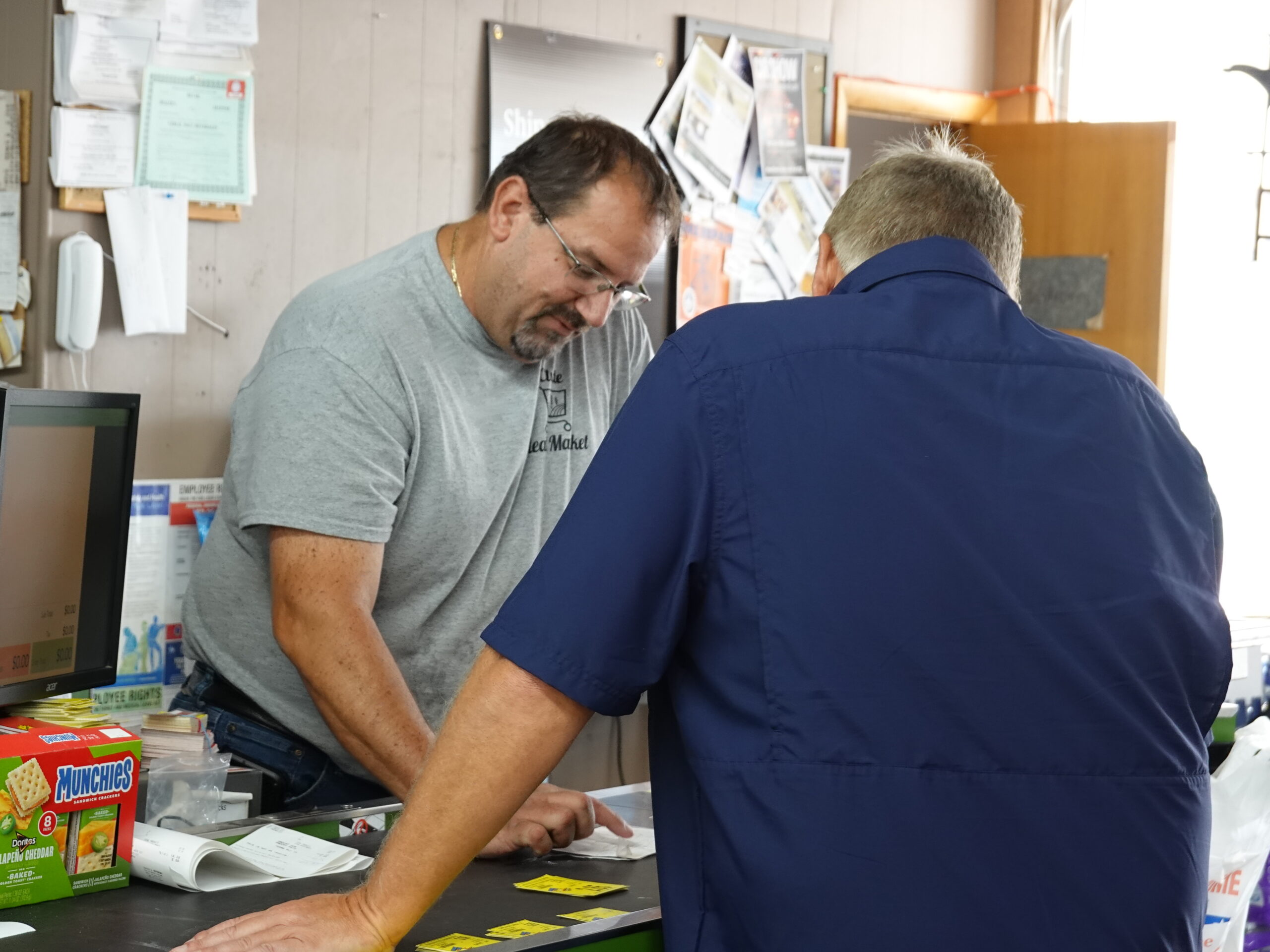 Steve James, Owner of Clyde Ideal Market shows Network Kansas funded renovation photos to Tim Biems of CloudCorp.