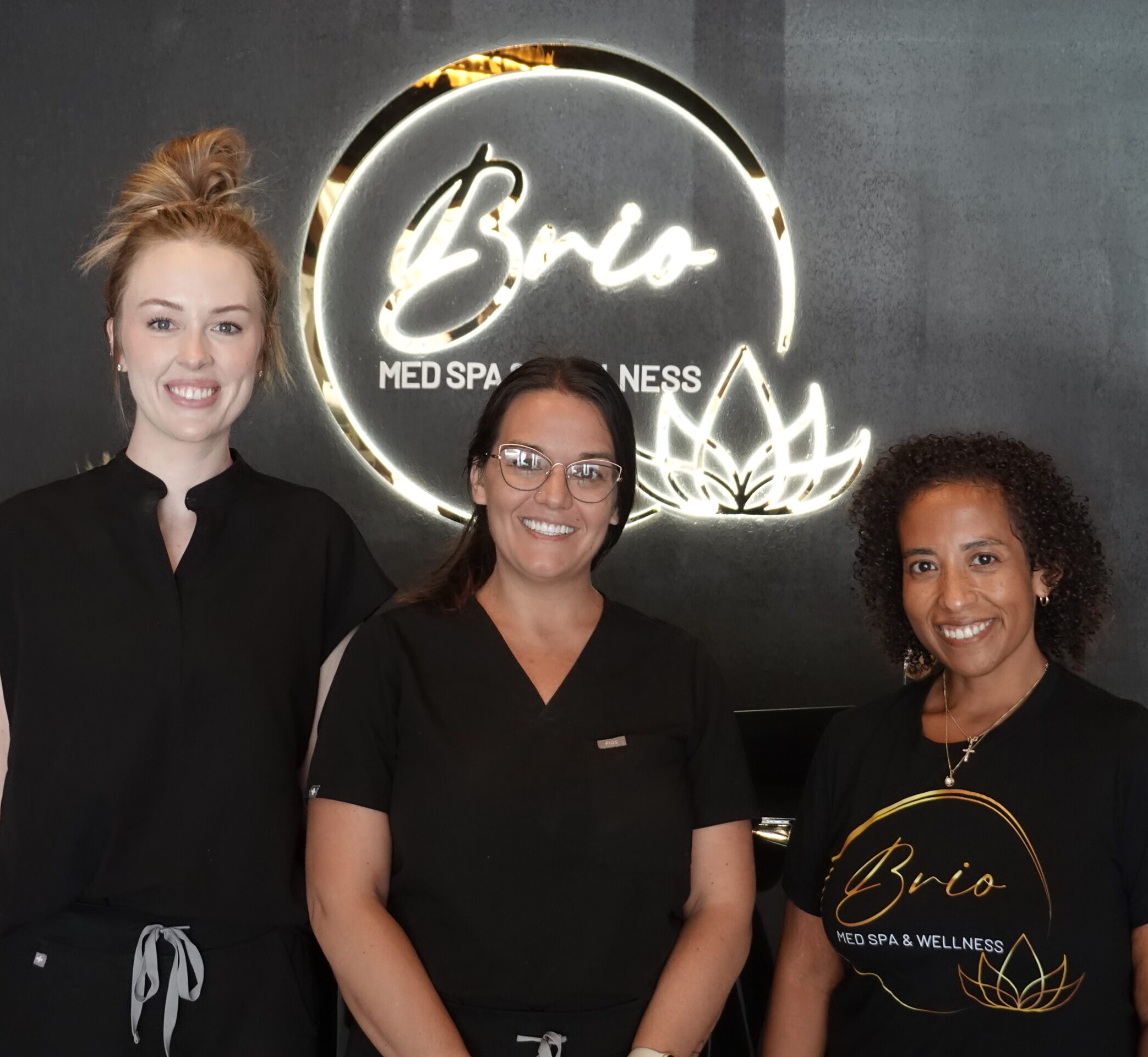 Brio Med Spa & Wellness Staff standing in front of business sign.