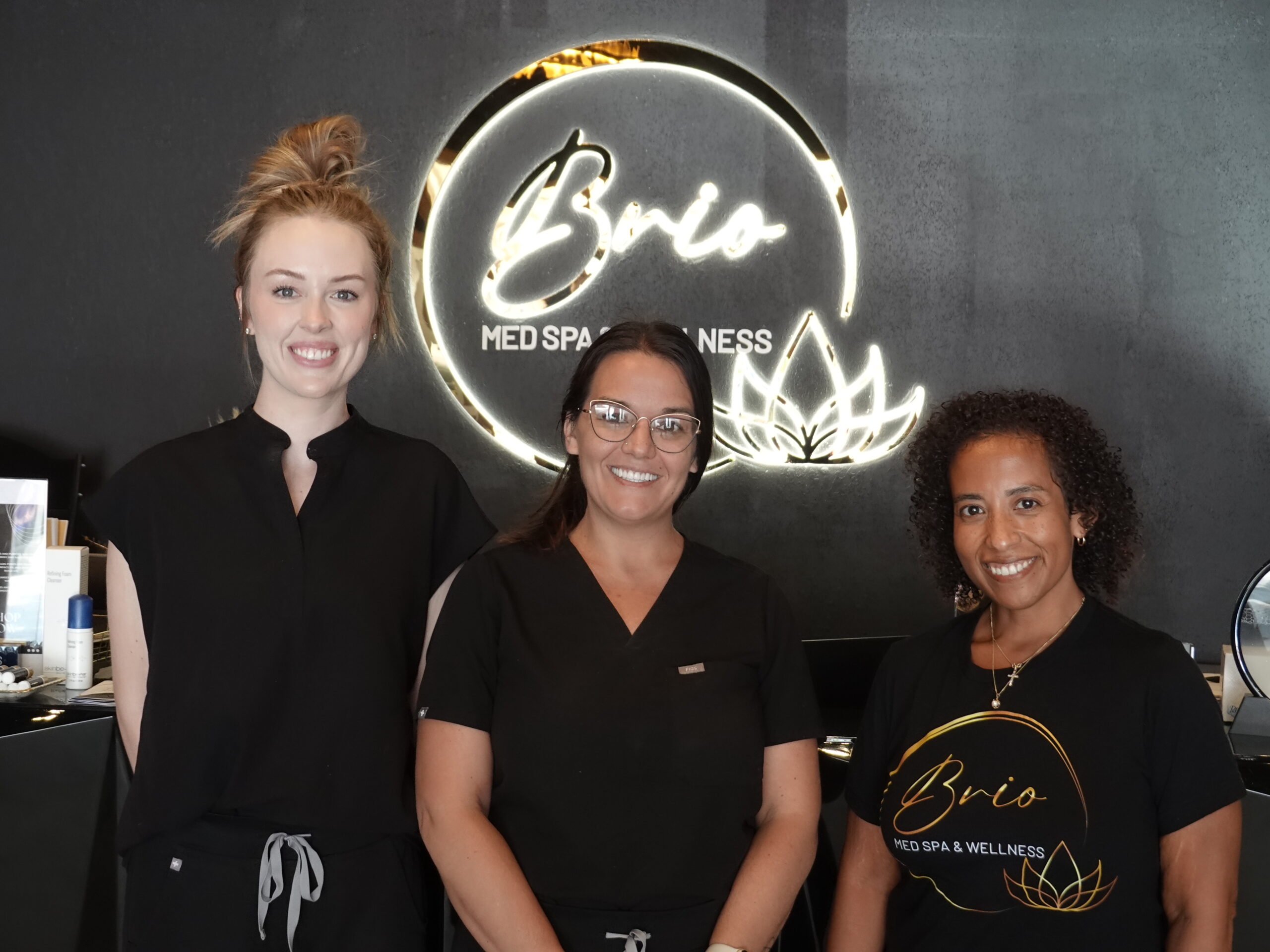 Brio Med Spa & Wellness Staff standing in front of business sign.